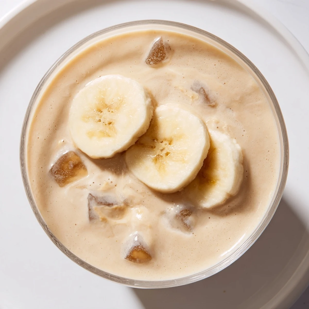 A thick Peanut Butter Banana Smoothie, glistening with melted peanut butter, perfect for a quick snack.