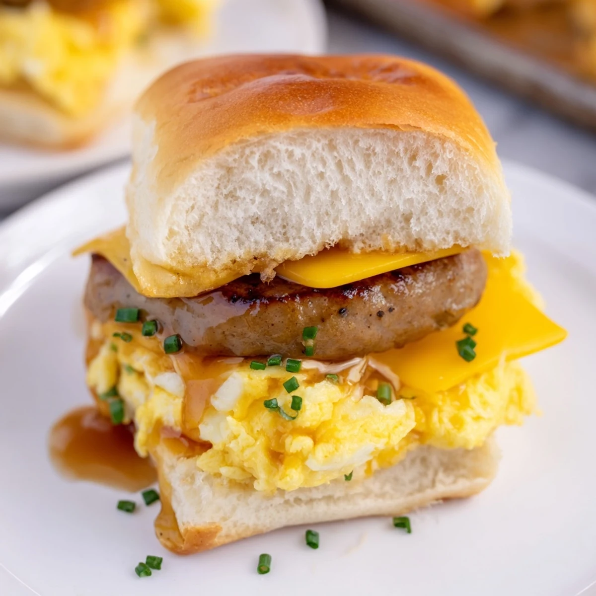 Golden, melty cheese and sausage peek from soft, toasted buns in these Mini Breakfast Sliders.