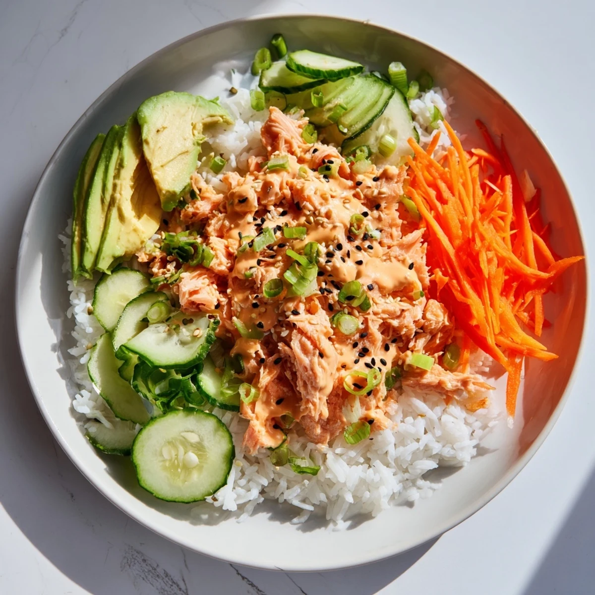 Imagine the flavorful Spicy Canned Salmon Rice Bowl: steamed rice topped with flaky salmon and fresh toppings.