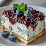 Lemon Blueberry Shortbread Mousse Cake slices layered with creamy mousse on a ceramic platter.