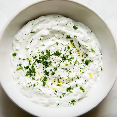 A vibrant bowl of lightened-up Greek Yogurt Ranch Dip, perfect for dipping carrots and celery sticks.