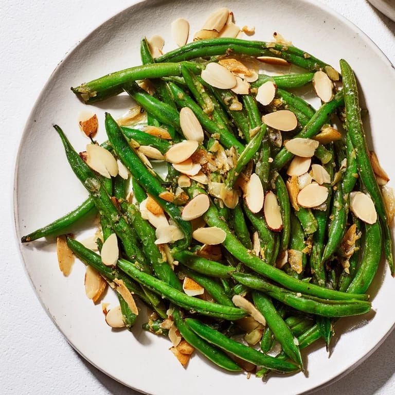 Tender, bright-green Sautéed Green Beans with garlic and almonds seasoned for perfect flavor.