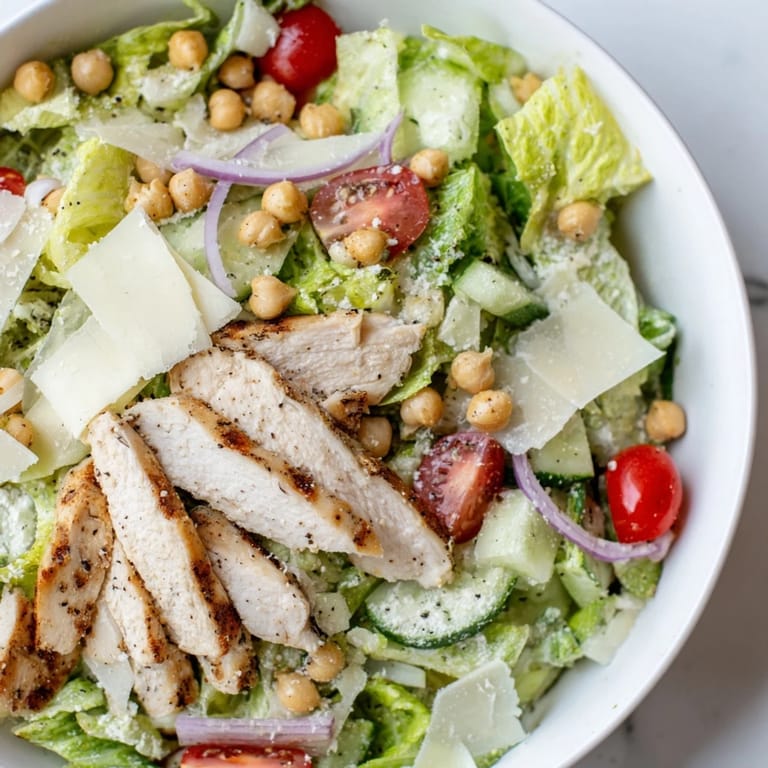 A vibrant Chicken Caesar Pasta-less Bowl with juicy chicken slices and crisp romaine lettuce is shown.